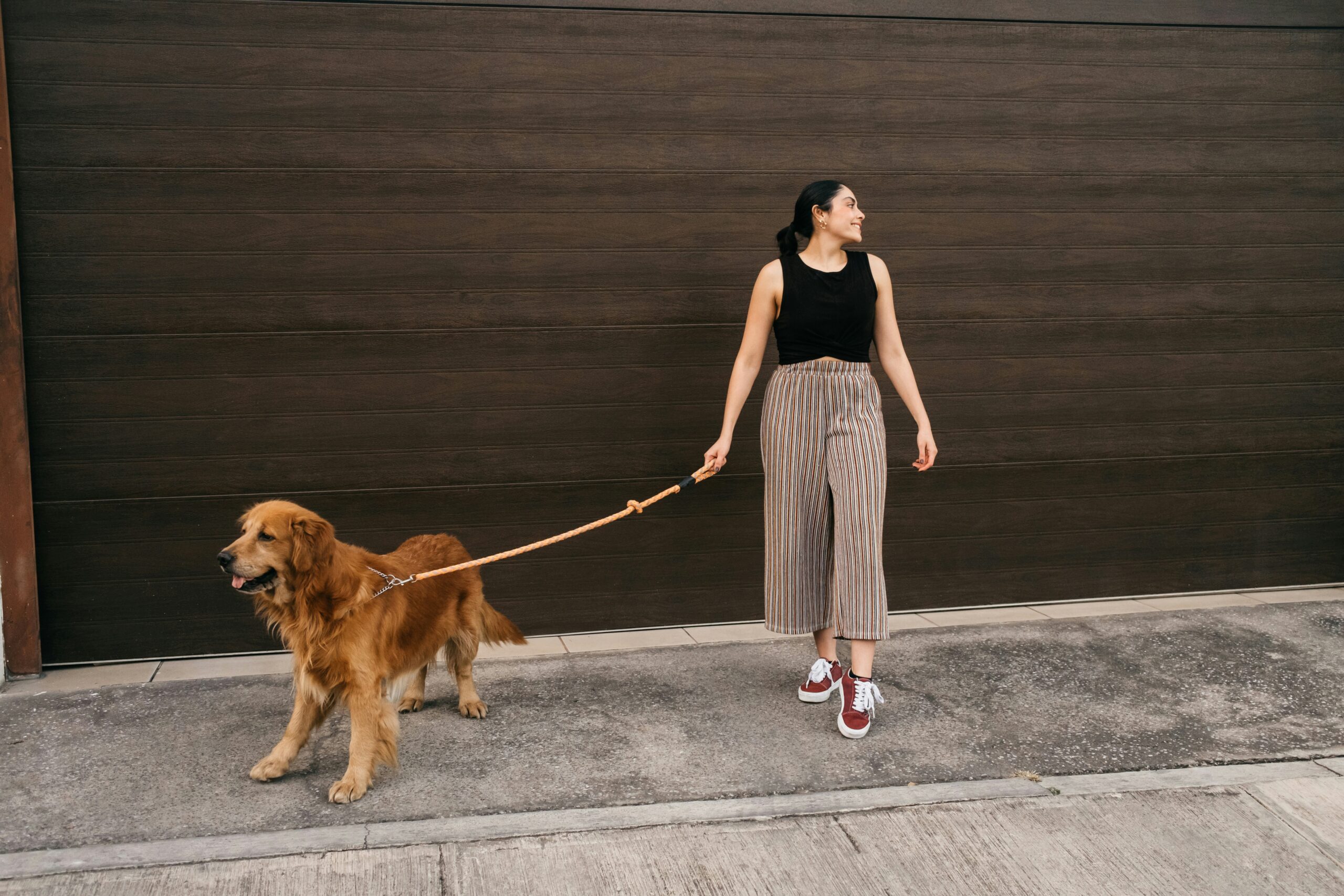happy woman enjoying walking her dog outside